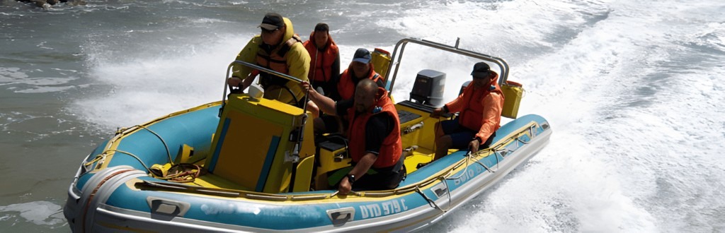 Students in life jackets skippering a rigid inflatable boat during practical training