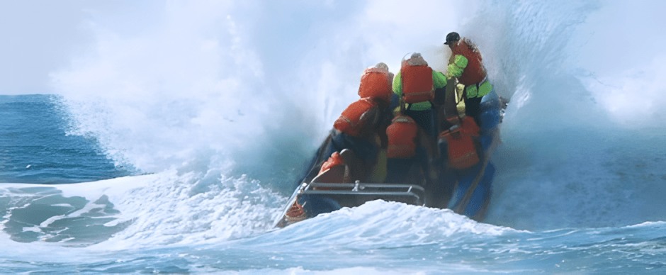 A rescue boat punching through surf during a launch